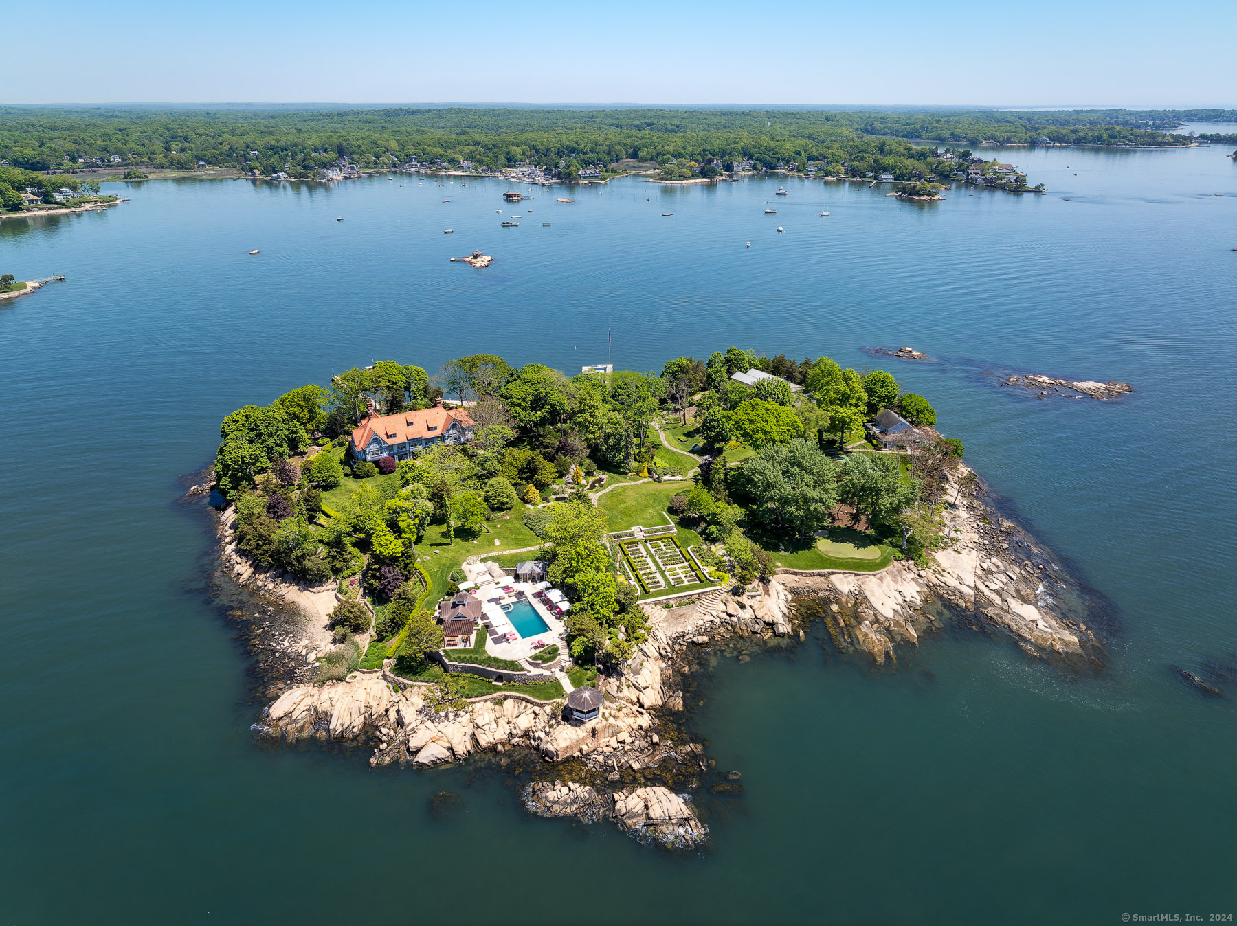 Aerial view of Rogers Island showcasing the mansion, lush gardens, and surrounding waters.