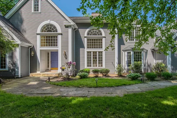 Front entrance of a grand Colonial home in Farmington, CT, with pristine landscaping and large arched windows.