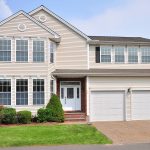 Front view of the two-story Colonial-style home at 16 Cobble Ct, Unionville, CT 06085, featuring a double garage and well-maintained landscaping.