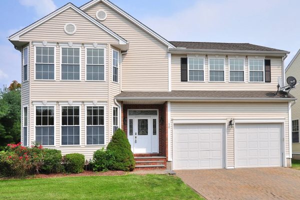 Front view of the two-story Colonial-style home at 16 Cobble Ct, Unionville, CT 06085, featuring a double garage and well-maintained landscaping.