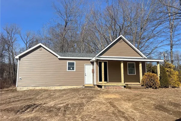 A small, unfinished single-family home at 196 Brickyard Rd, Farmington, CT, with beige siding, no landscaping, and missing doors and windows, sitting on a barren dirt lot.