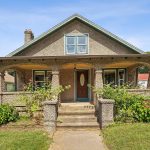 1920s bungalow at 1690 Farmington Avenue, Unionville, CT, featuring a charming front porch with unique stonework and lush greenery.