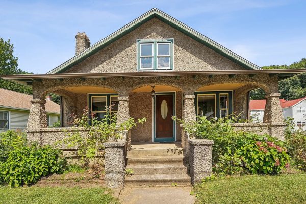 1920s bungalow at 1690 Farmington Avenue, Unionville, CT, featuring a charming front porch with unique stonework and lush greenery.