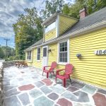 Interior of the historic colonial home at 109 River Rd, Unionville, CT, featuring rustic wood beams and bright yellow exterior.