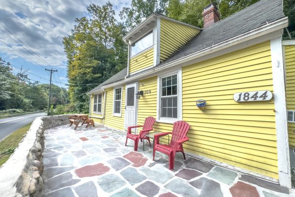 Interior of the historic colonial home at 109 River Rd, Unionville, CT, featuring rustic wood beams and bright yellow exterior.